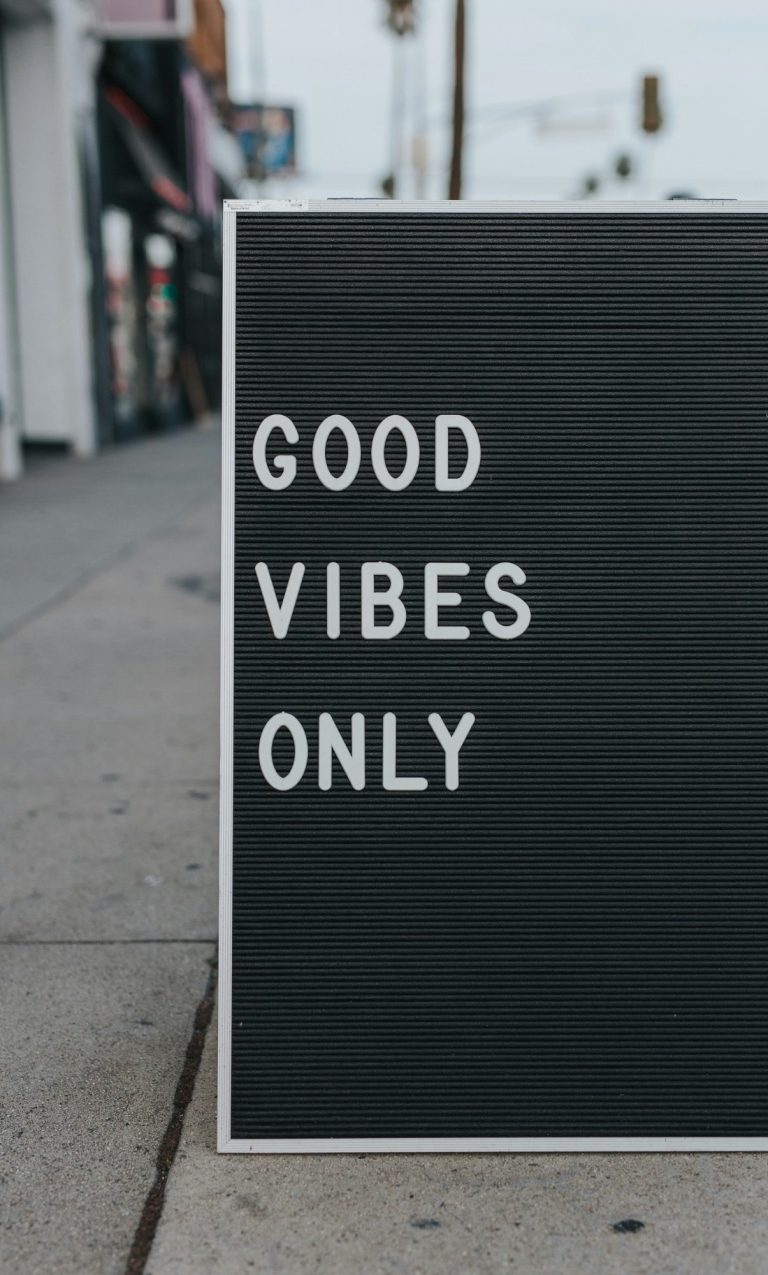 A black sign with white text reading "GOOD VIBES ONLY".